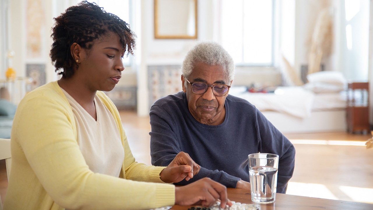 Assisted Living Caregiver working with an elderly man with meication